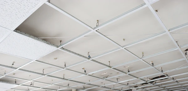Intérieur de bâtiment en construction ou rénovation avec plafond suspendu en cours d'installation